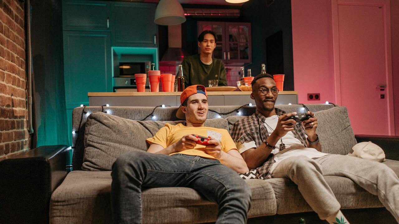 Two friends in a living room gaming session